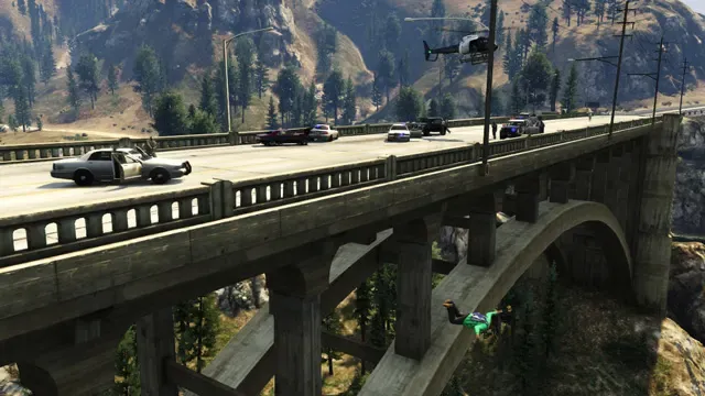 Police cars chase across an arched bridge over a wooded canyon while a helicopter follows