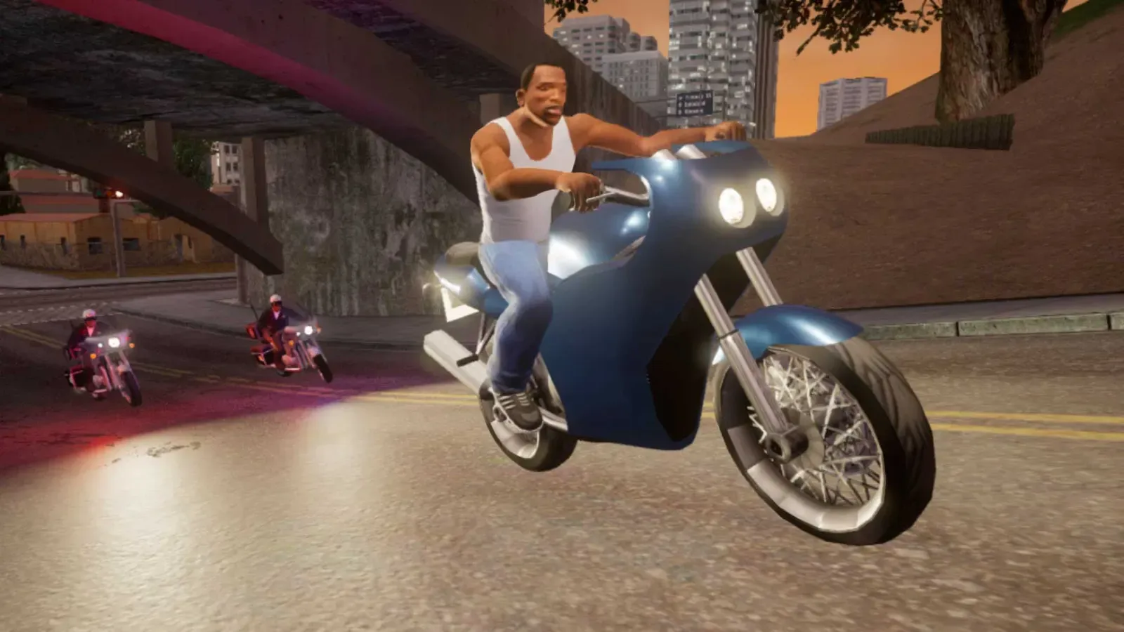 Definitive Edition: CJ rides a blue sports motorcycle under an overpass at dusk while two bikers follow behind
