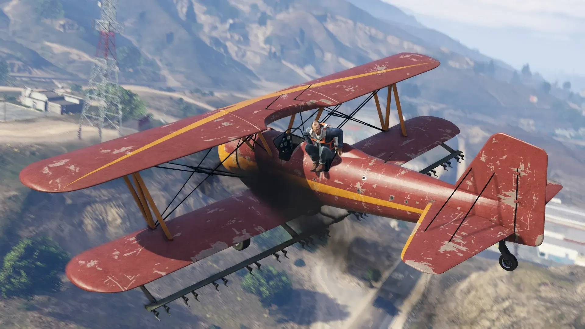 A weathered red Duster crop duster biplane banks low over dry hills and power lines