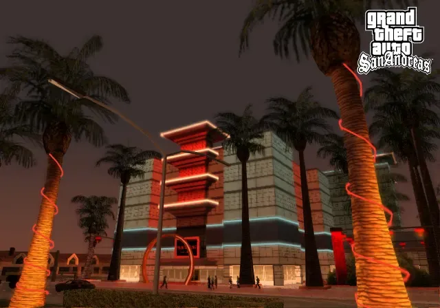 Original game: the Four Dragons Casino glows red and blue at night behind palm trees wrapped in lights on The Strip