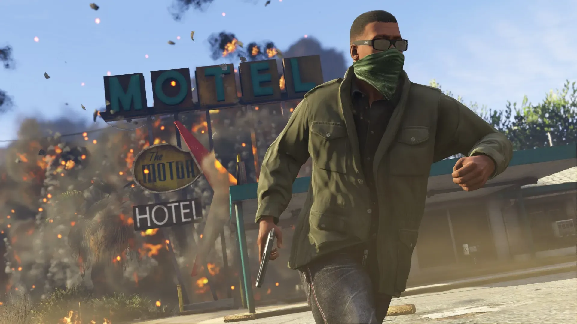 Franklin in a bandana mask runs from an exploding motel with a pistol in hand