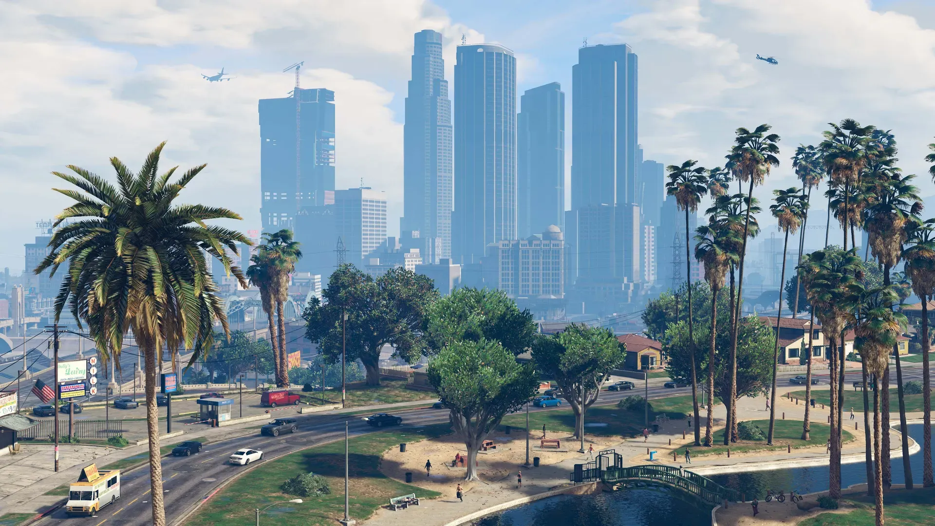 Downtown Los Santos towers on a clear day, seen over a park lined with palm trees and a busy road
