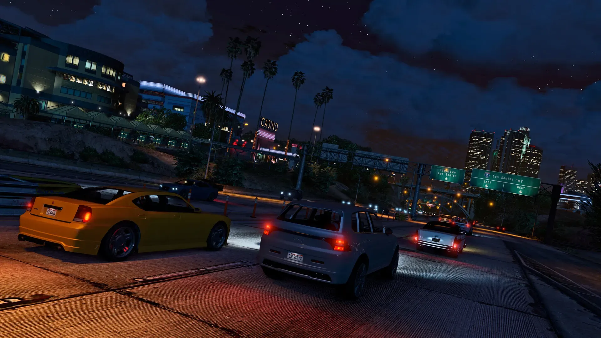 Evening traffic on a Los Santos freeway, with lit office buildings and city towers ahead
