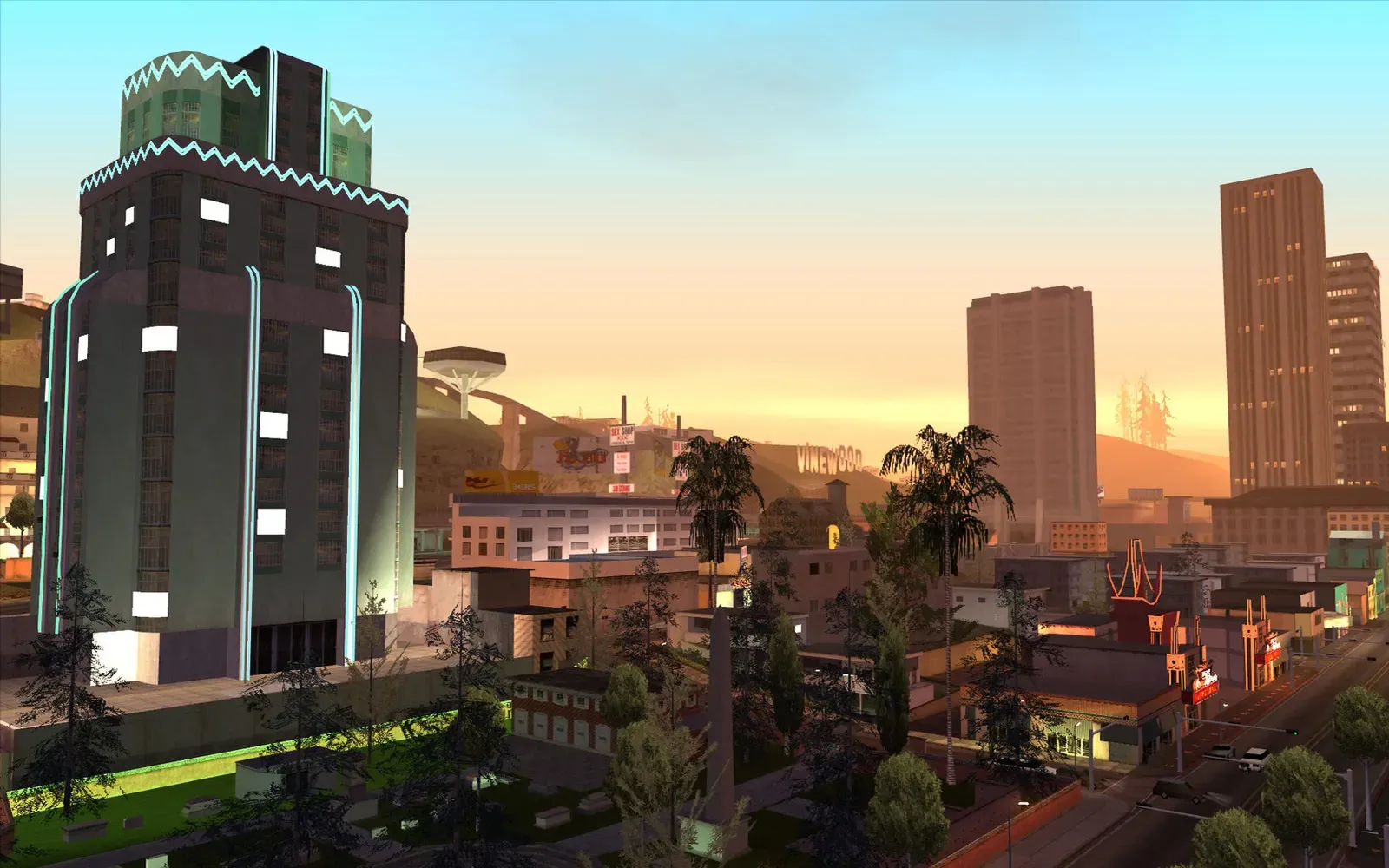 Original game (PC): Los Santos towers at dusk, seen over a busy neighbourhood with a lit tower block in front