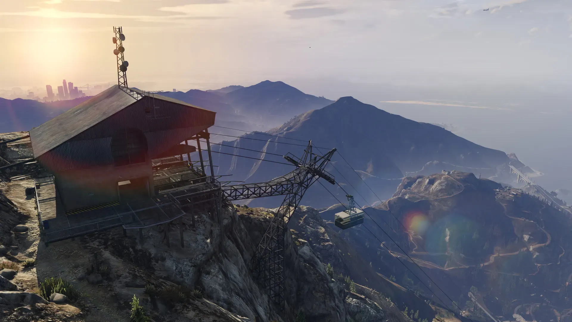 The summit station of the cable car on Mount Chiliad, with a cable car descending and the Los Santos skyline far in the distance