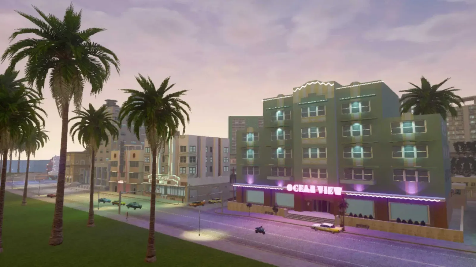 The Ocean View hotel, a pale green Art Deco building with a pink neon sign, seen across a park lined with palm trees
