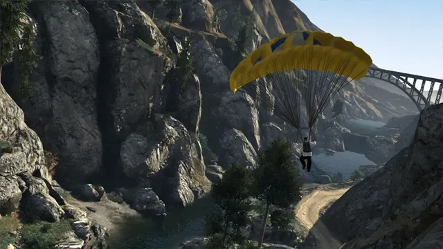A parachutist glides down into a rocky canyon below a road bridge