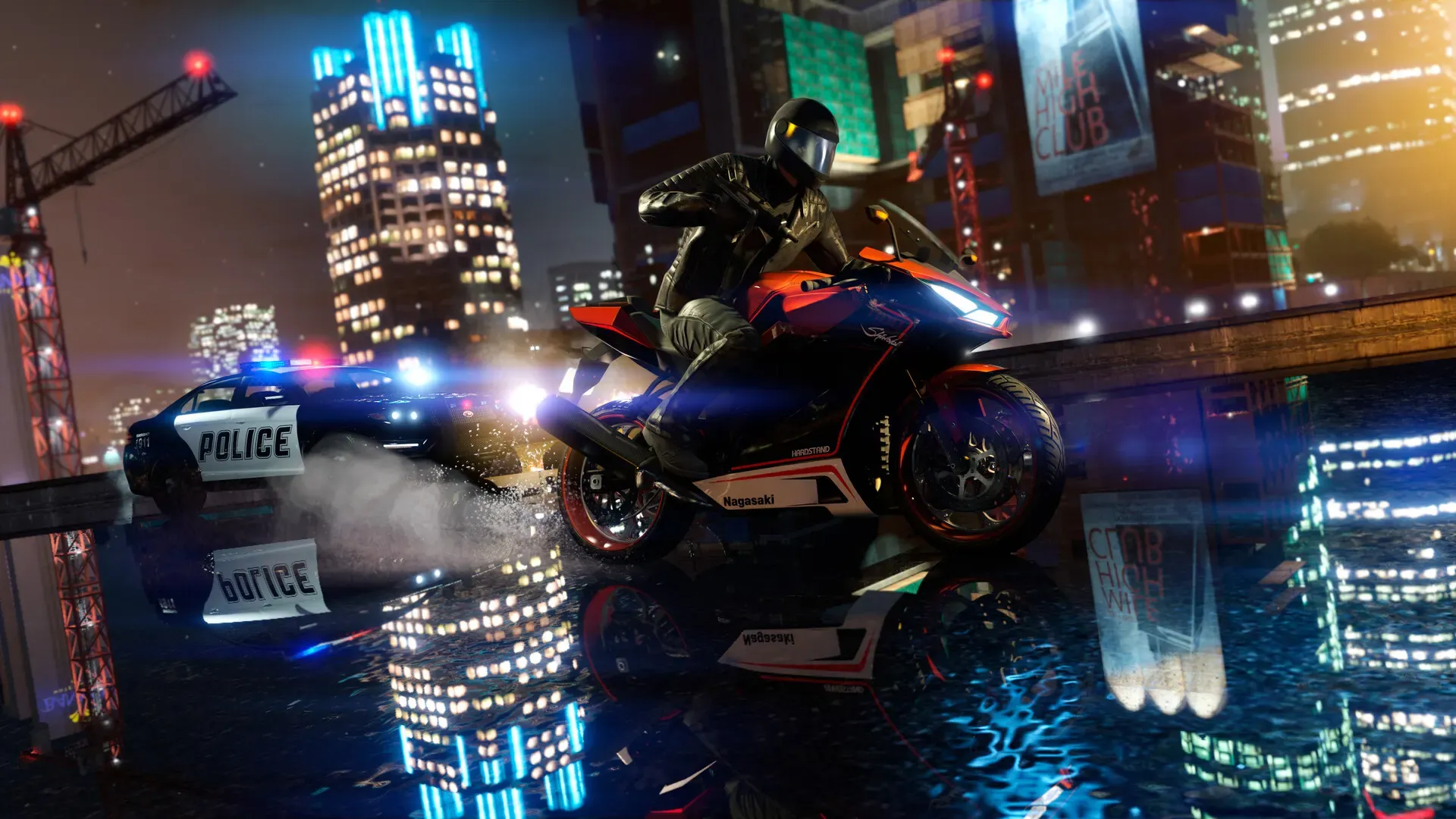 A rider on a sports motorcycle races a police cruiser across a wet street lit by neon city towers at night