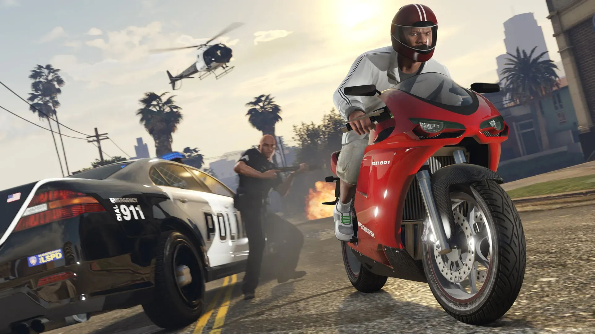 A rider on a red sports bike speeds past police cars and officers as a helicopter circles overhead
