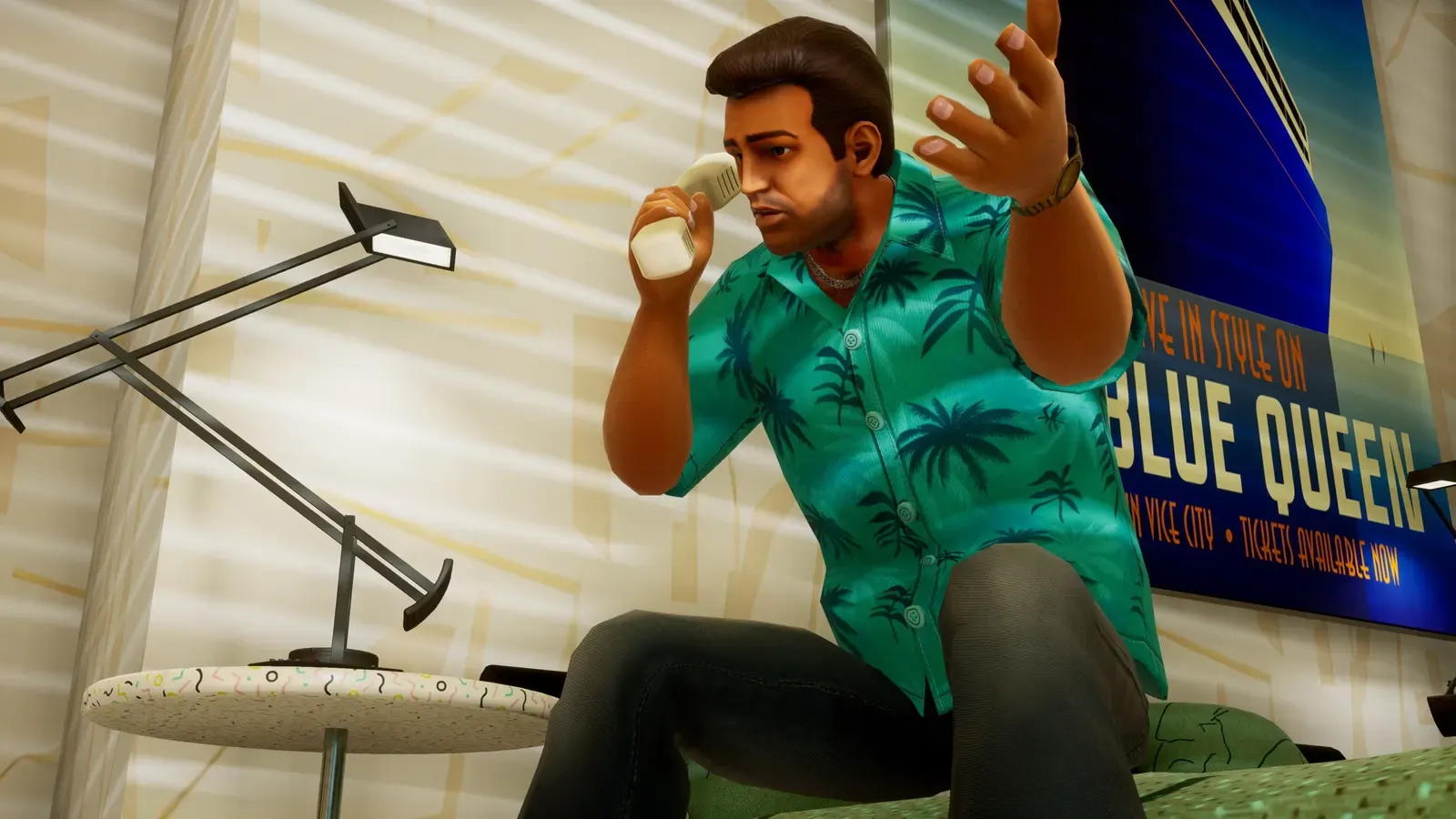 Tommy in his Hawaiian shirt sits on a bed taking a phone call, with a Blue Queen cruise poster on the wall behind