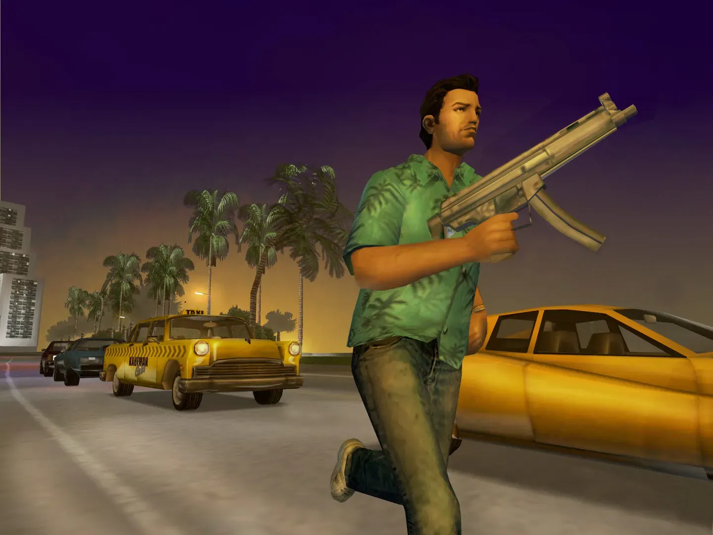 Tommy in a green patterned shirt runs past yellow taxis on a palm lined street at dusk, holding a submachine gun