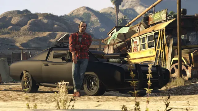 Trevor in a plaid shirt leans on a matte black muscle car outside a ramshackle desert shack