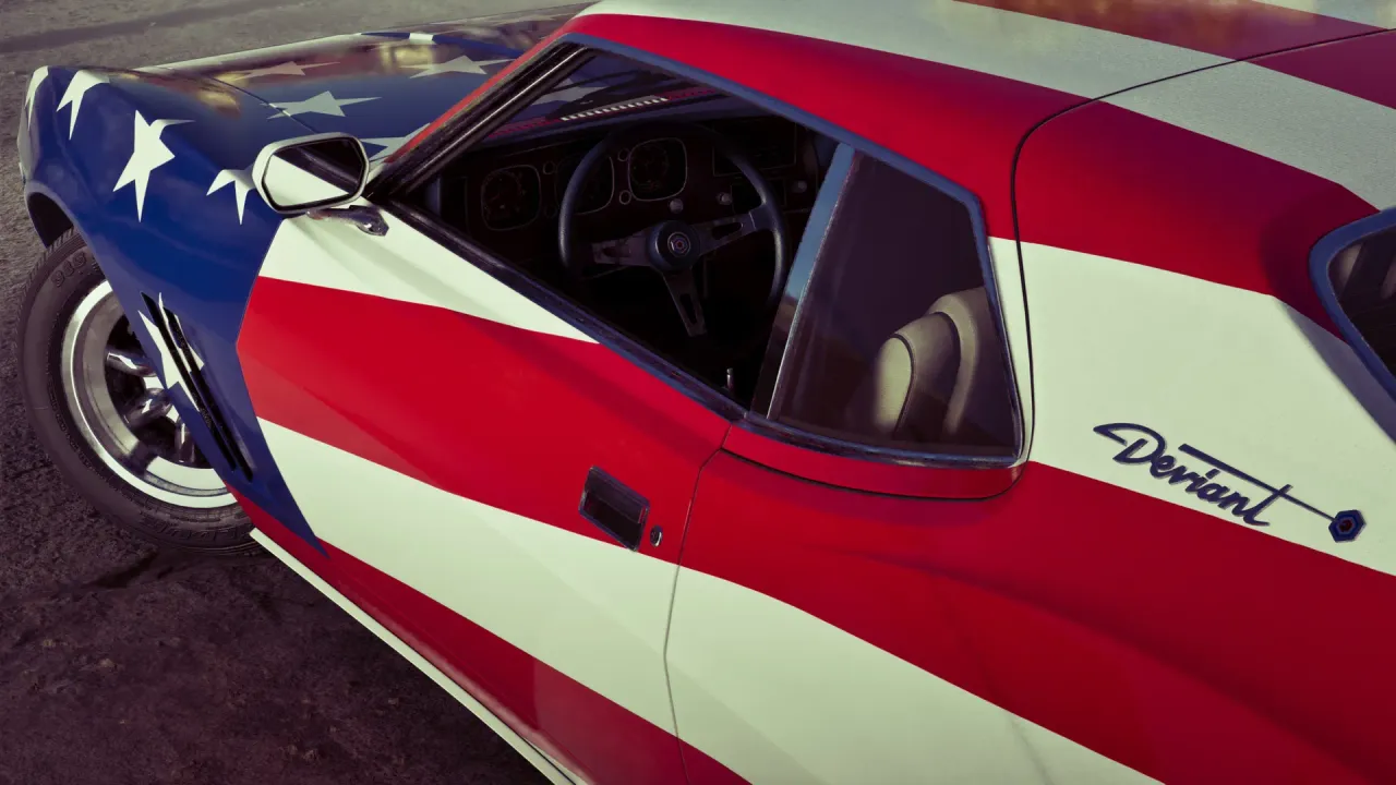 Side view of a muscle car covered in a red, white, and blue stars and stripes livery.