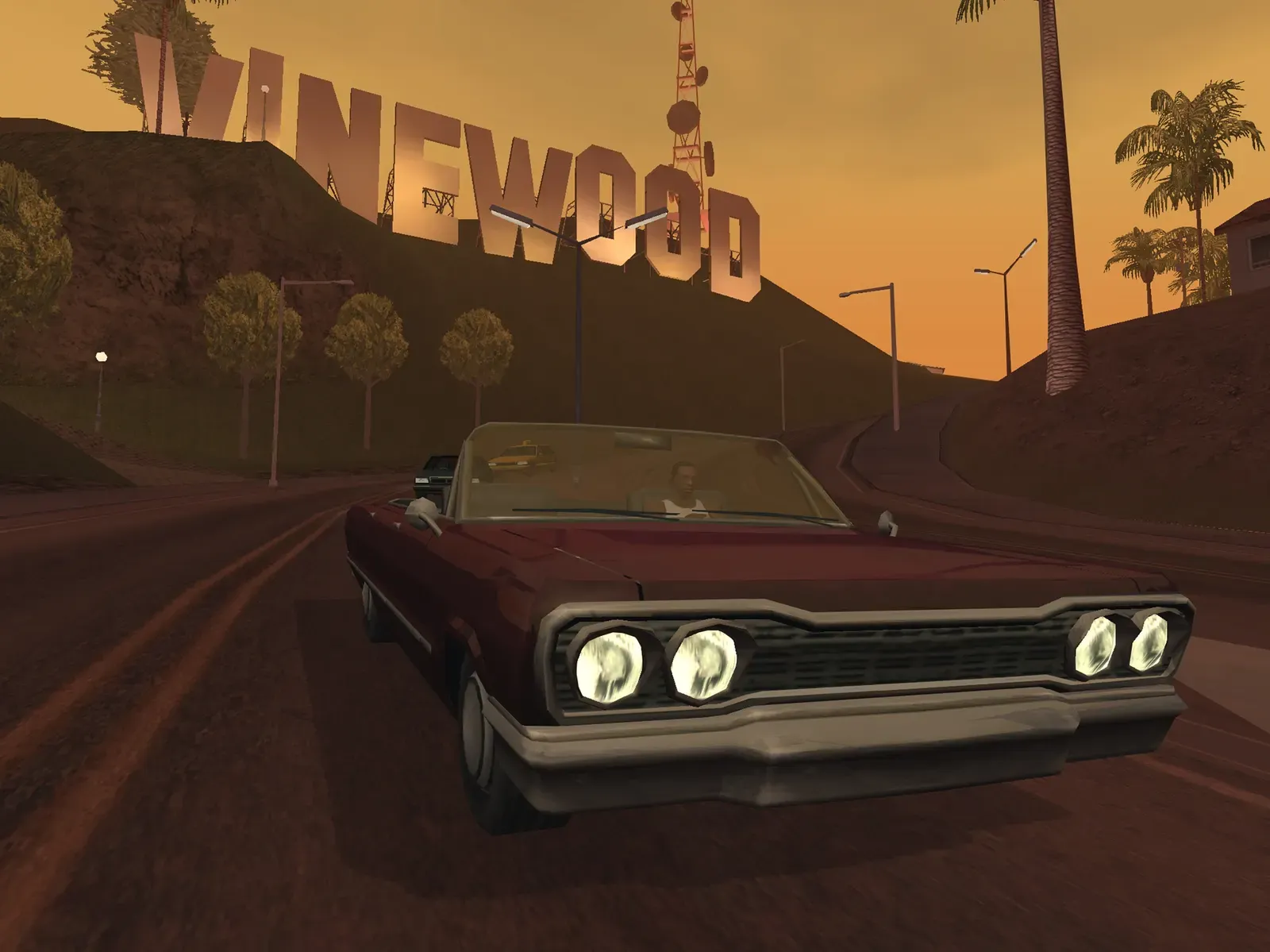 Original game, 2013 mobile release: a dark red lowrider drives up a hill road at dusk below the Vinewood sign